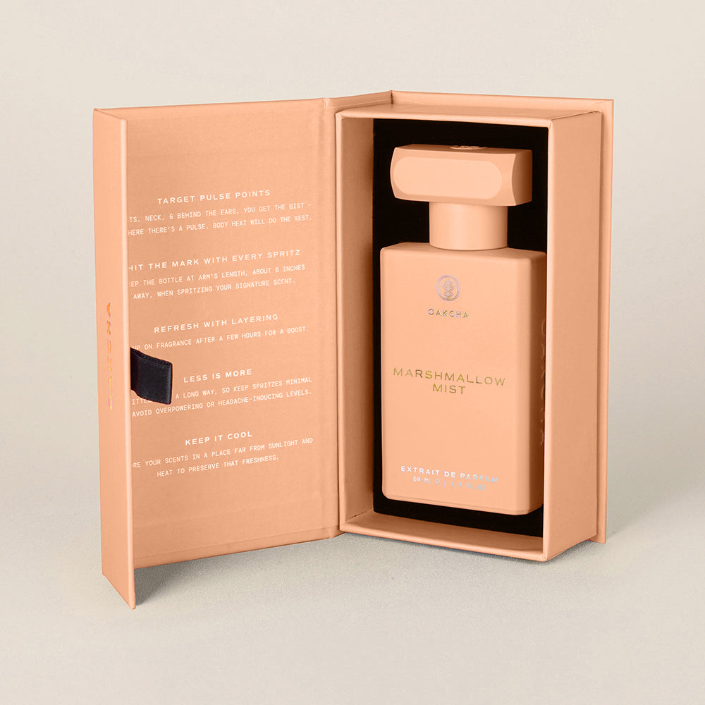 Perfume bottle in a pink box with 'Lemon Cake' text on a light gray background