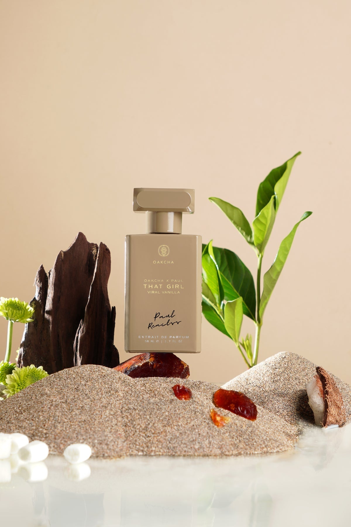 Perfume bottle labeled 'That Girl' on a decorative stone surface with plants and flowers.