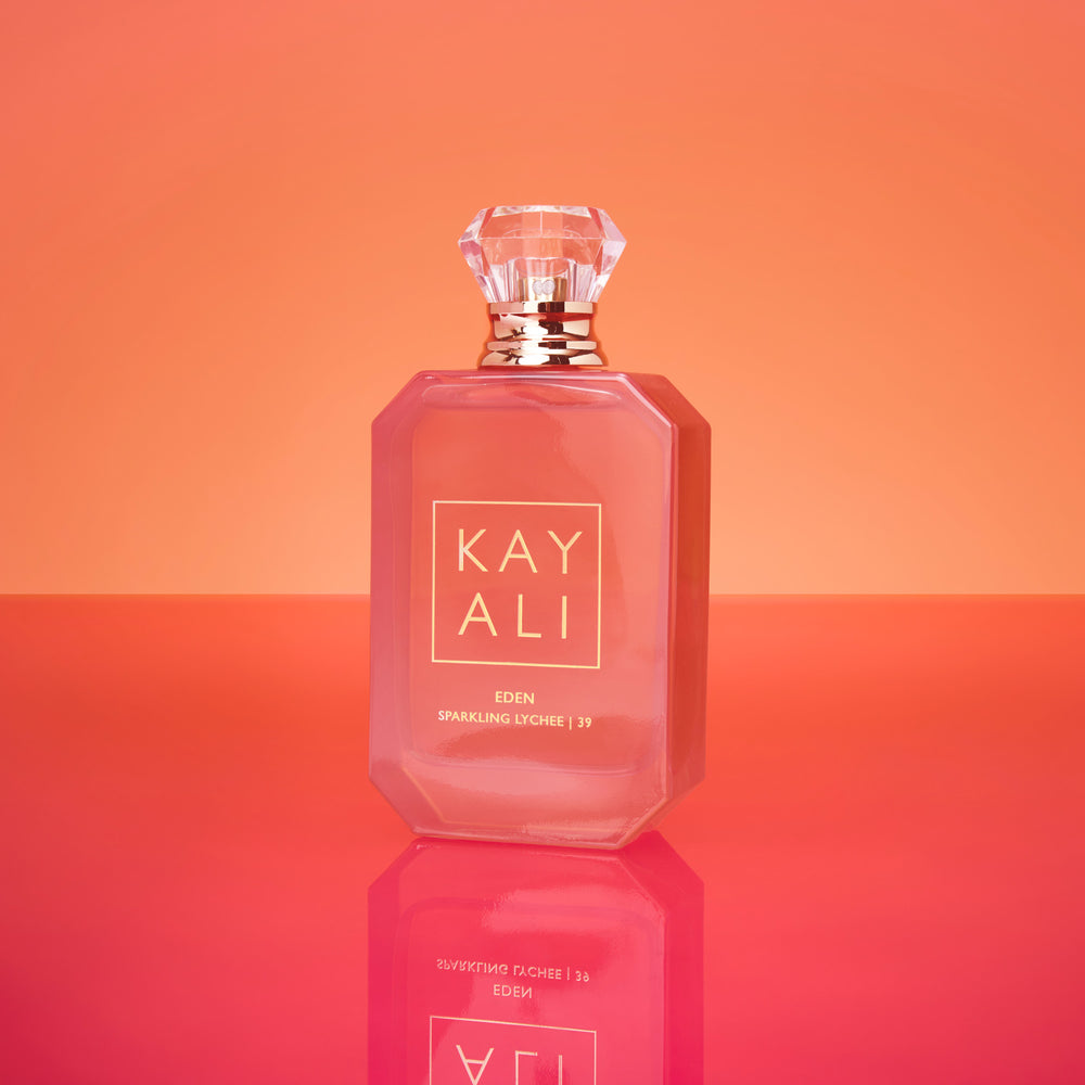 Perfume bottle with 'KAY ALI' branding on an orange gradient background