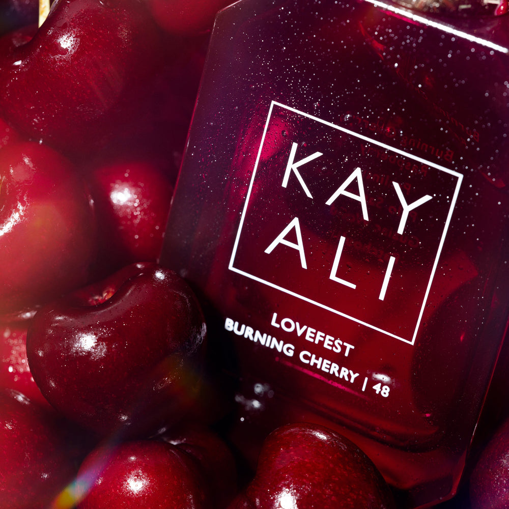 Red nail polish bottle with 'KAY ALI' branding surrounded by cherries